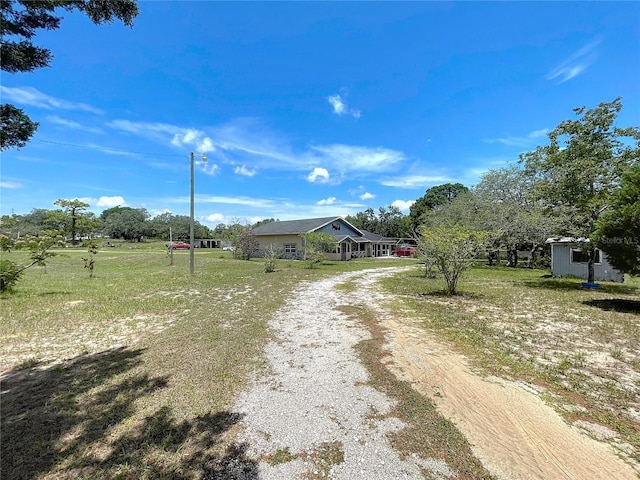13341 Hexam Rd, Weeki Wachee, FL 34613 - view of front facade featuring dirt driveway and an outbuilding