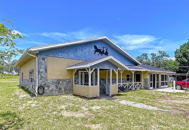 13341 Hexam Rd, Weeki Wachee, FL 34613 - view of front facade featuring stone siding, a front lawn, and stucco siding