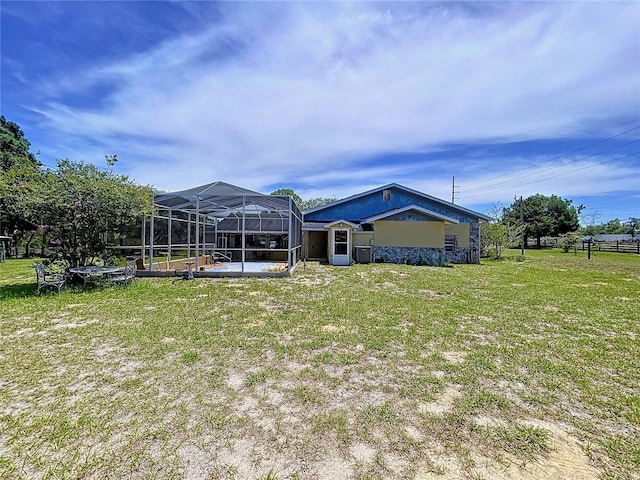 13341 Hexam Rd, Weeki Wachee, FL 34613 - rear view of house with a lawn, a lanai, and stucco siding