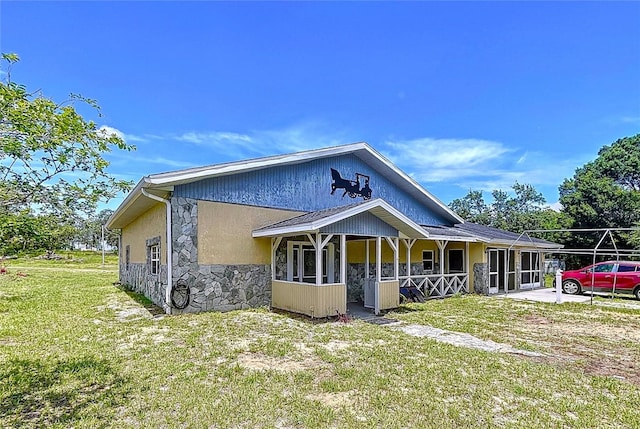 13341 Hexam Rd, Weeki Wachee, FL 34613 - view of front of home with stone siding, a front yard, and a porch