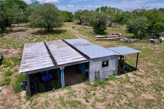 13341 Hexam Rd, Weeki Wachee, FL 34613 - exterior space with a pole building, view of wooded area, an outbuilding, a metal roof, and an attached carport