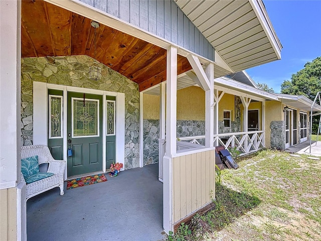 13341 Hexam Rd, Weeki Wachee, FL 34613 - entrance to property featuring stone siding, covered porch, and stucco siding