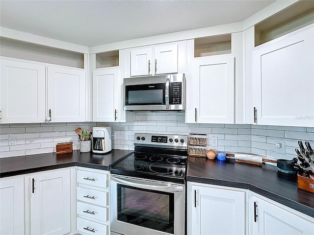 8851 C 469, Center Hill, FL 33514 - kitchen featuring stainless steel appliances, dark countertops, white cabinetry, and tasteful backsplash