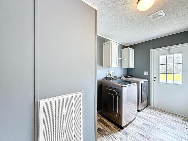 8851 C 469, Center Hill, FL 33514 - laundry room featuring cabinet space, washing machine and dryer, light wood finished floors, and a textured ceiling
