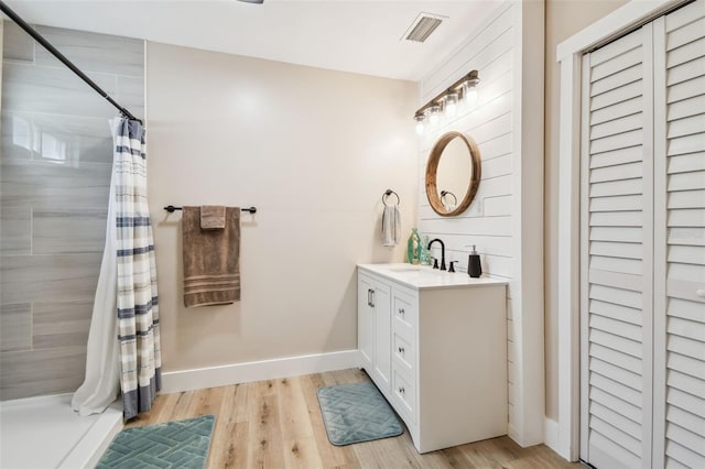 1529 Essex Dr N, Saint Petersburg, FL 33710 - full bathroom featuring vanity, tiled shower, and wood finished floors