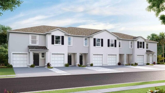5112 Captain Davis Dr, Wimauma, FL 33598 - view of property featuring a garage, stucco siding, driveway, and a shingled roof