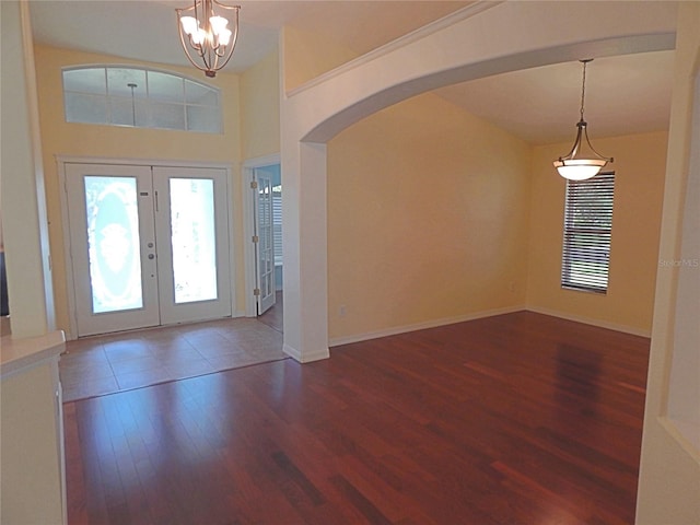 5815 Heronview Crescent Dr, Lithia, FL 33547 - entrance foyer with wood finished floors, arched walkways, french doors, a chandelier, and baseboards