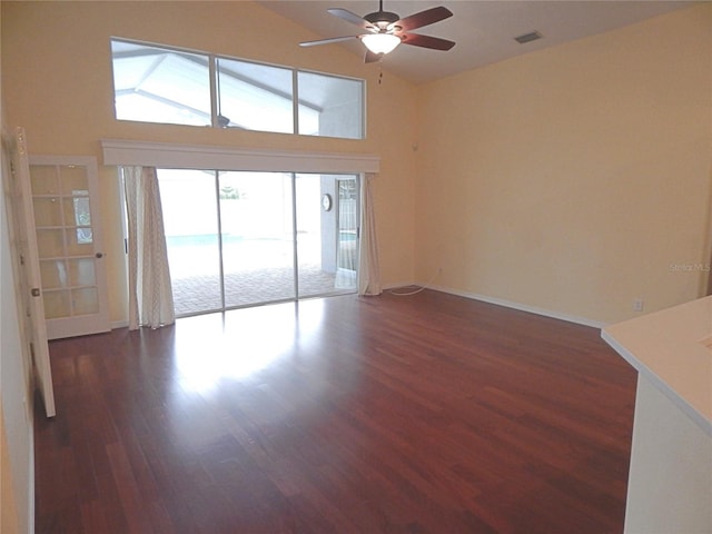 5815 Heronview Crescent Dr, Lithia, FL 33547 - empty room with dark wood-type flooring, a ceiling fan, high vaulted ceiling, and baseboards