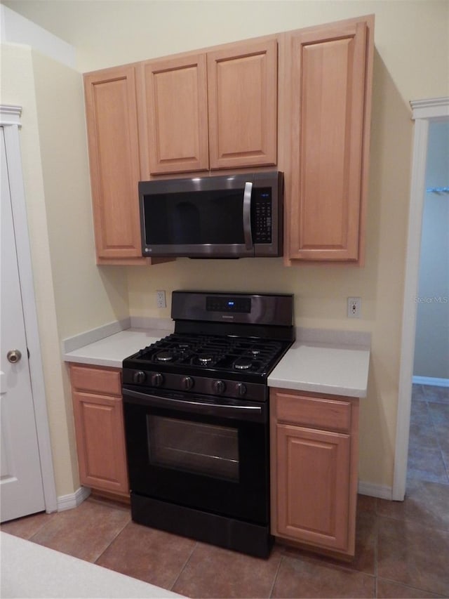 5815 Heronview Crescent Dr, Lithia, FL 33547 - kitchen featuring black gas stove, stainless steel microwave, light countertops, and baseboards