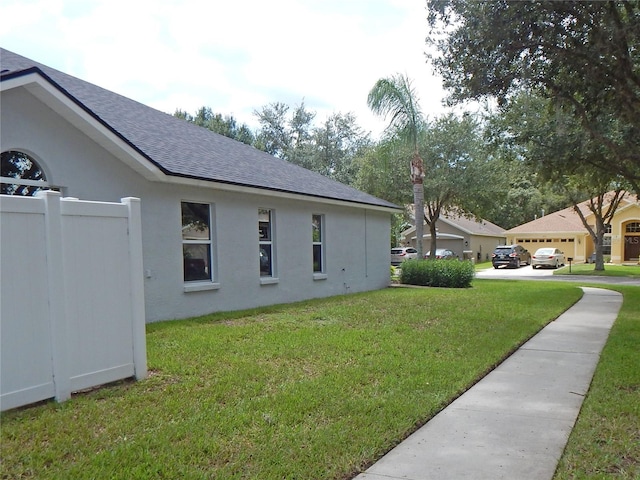 5815 Heronview Crescent Dr, Lithia, FL 33547 - view of property exterior featuring roof with shingles, a yard, and stucco siding