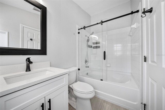 11363 Cocoa Beach Dr, Riverview, FL 33569 - full bath with vanity, toilet, shower / bath combination with glass door, and wood finished floors