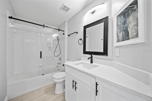 11363 Cocoa Beach Dr, Riverview, FL 33569 - full bath featuring toilet, vanity, combined bath / shower with glass door, and wood finished floors