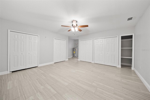 11363 Cocoa Beach Dr, Riverview, FL 33569 - unfurnished bedroom featuring water heater, multiple closets, baseboards, and ceiling fan