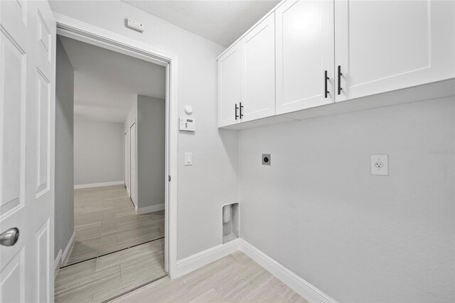 11363 Cocoa Beach Dr, Riverview, FL 33569 - laundry room featuring electric dryer hookup, baseboards, cabinet space, and light wood-type flooring
