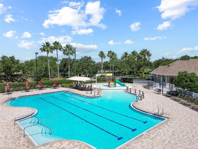 11363 Cocoa Beach Dr, Riverview, FL 33569 - community pool featuring a patio, view of scattered trees, and a water slide