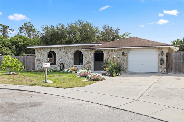 8918 Carmen Ln, Port Richey, FL 34668 - ranch-style home with stone siding, a garage, and driveway