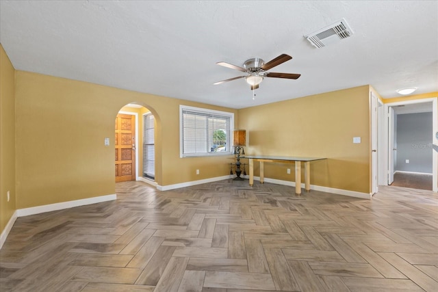 8918 Carmen Ln, Port Richey, FL 34668 - empty room featuring arched walkways, baseboards, and ceiling fan