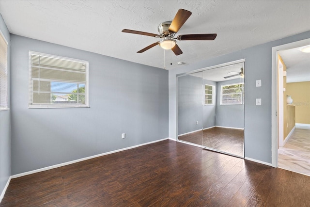 8918 Carmen Ln, Port Richey, FL 34668 - unfurnished bedroom with wood finished floors, a closet, baseboards, ceiling fan, and a textured ceiling