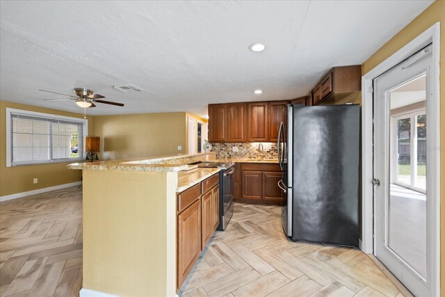8918 Carmen Ln, Port Richey, FL 34668 - kitchen featuring appliances with stainless steel finishes, a peninsula, brown cabinets, a ceiling fan, and recessed lighting