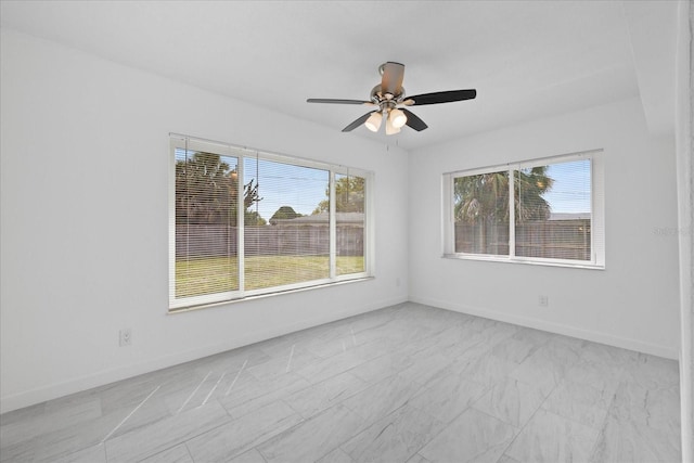 8918 Carmen Ln, Port Richey, FL 34668 - empty room featuring plenty of natural light, a ceiling fan, and baseboards