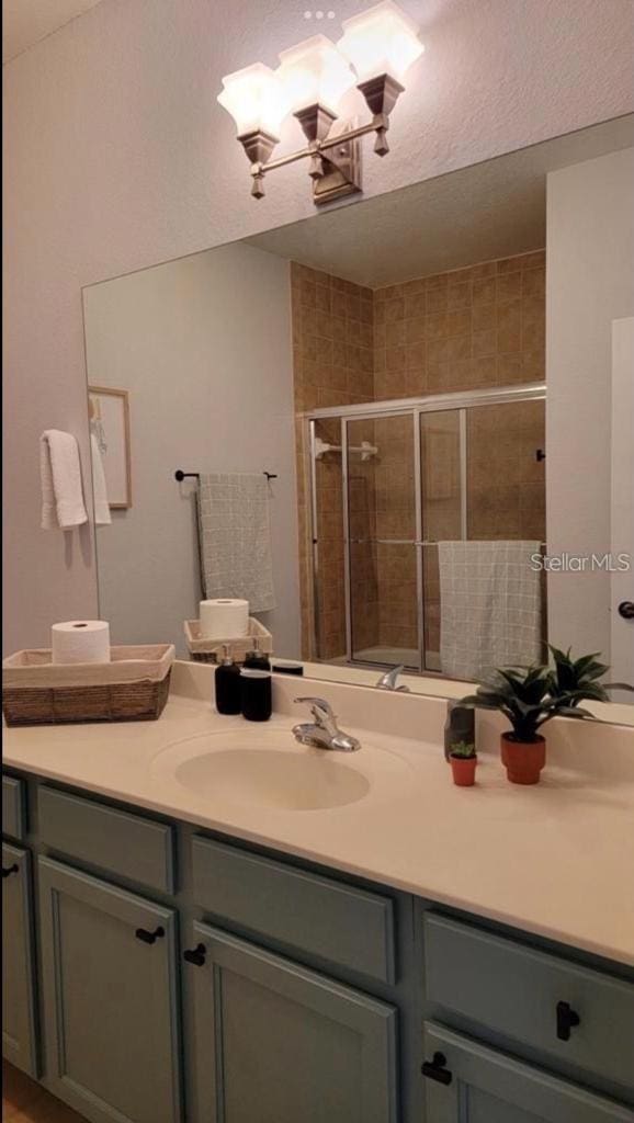 3175 Feltrim Pl Unit 405, Kissimmee, FL 34747 - bathroom with vanity, a shower stall, and a chandelier