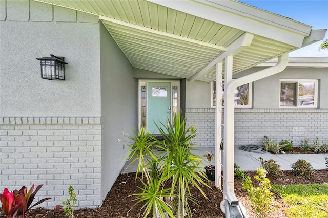 94 Nicholas Dr, Dunedin, FL 34698 - view of exterior entry featuring brick siding and stucco siding