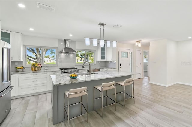 94 Nicholas Dr, Dunedin, FL 34698 - kitchen featuring wall chimney exhaust hood, a sink, high quality appliances, white cabinetry, and recessed lighting