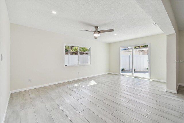 94 Nicholas Dr, Dunedin, FL 34698 - unfurnished room with healthy amount of natural light, a ceiling fan, wood finish floors, a textured ceiling, and baseboards