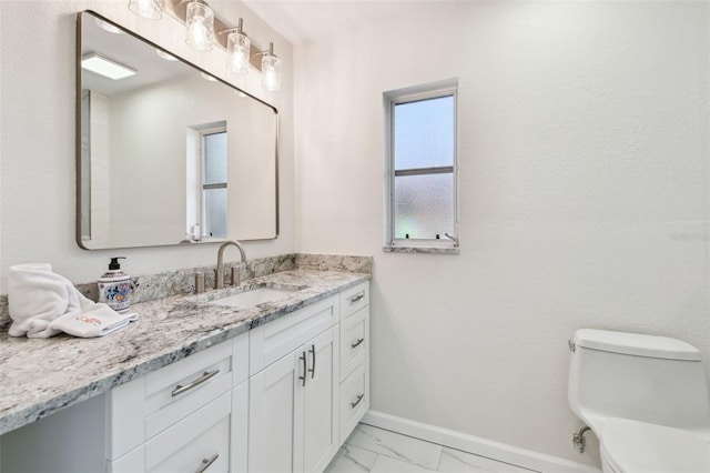 94 Nicholas Dr, Dunedin, FL 34698 - bathroom with vanity, marble look tile flooring, baseboards, and toilet