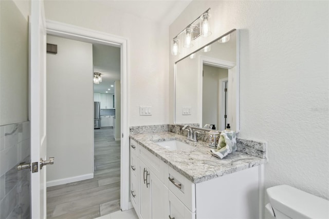94 Nicholas Dr, Dunedin, FL 34698 - bathroom with vanity, toilet, wood finished floors, and baseboards