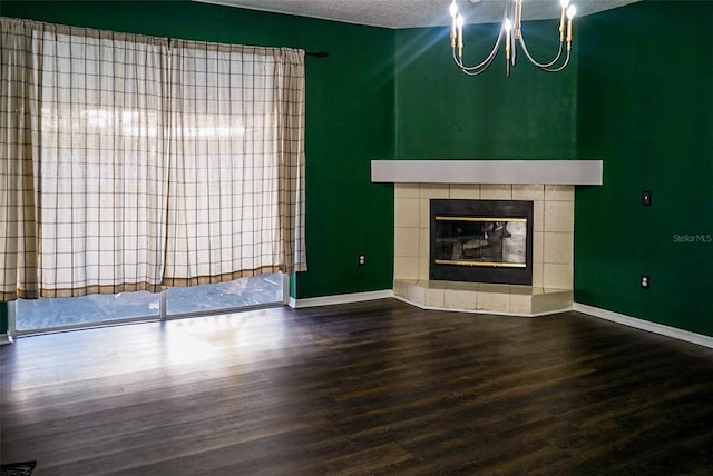 1204 Rinkfield Pl, Brandon, FL 33511 - unfurnished living room featuring a textured ceiling, wood finished floors, a chandelier, a tile fireplace, and baseboards