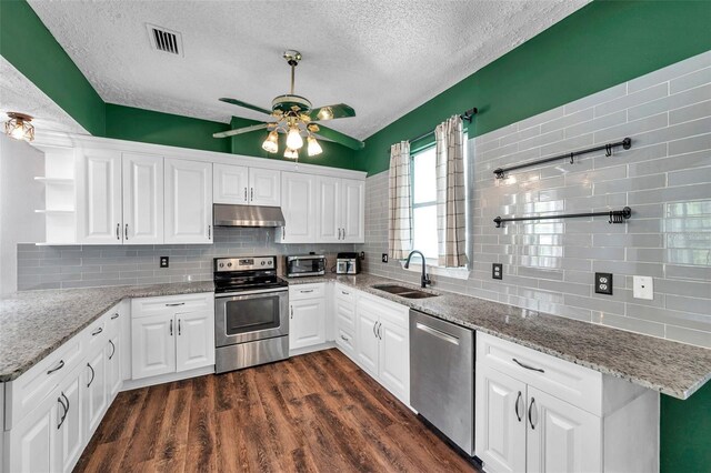 1204 Rinkfield Pl, Brandon, FL 33511 - kitchen with appliances with stainless steel finishes, open shelves, under cabinet range hood, a textured ceiling, and tasteful backsplash