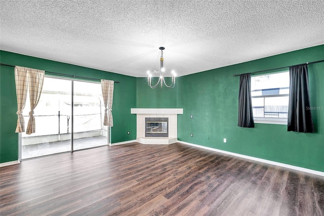 1204 Rinkfield Pl, Brandon, FL 33511 - unfurnished living room with a chandelier, wood finished floors, a textured ceiling, and a tiled fireplace