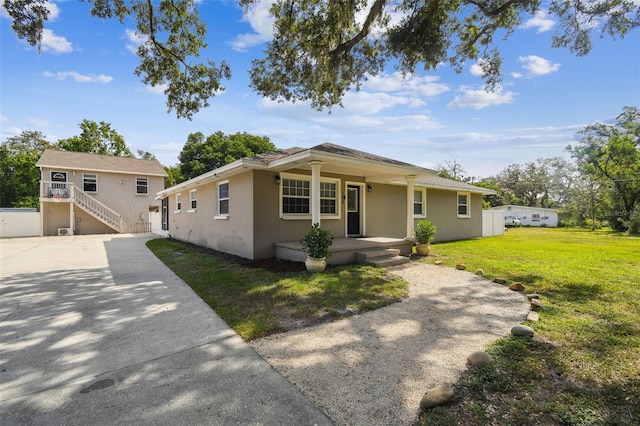 205 W 122nd Ave, Tampa, FL 33612 - view of front of house with covered porch, stucco siding, a front yard, and driveway