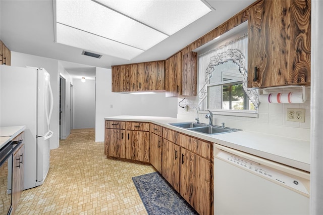 1211 Stony Brook Ln, Dunedin, FL 34698 - kitchen featuring white appliances, a sink, light countertops, backsplash, and light floors