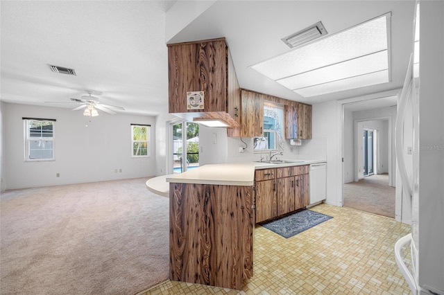 1211 Stony Brook Ln, Dunedin, FL 34698 - kitchen with white appliances, light carpet, light countertops, brown cabinets, and ceiling fan