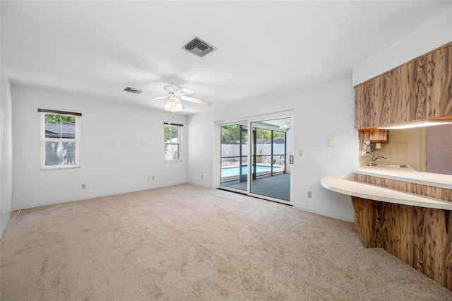 1211 Stony Brook Ln, Dunedin, FL 34698 - empty room with carpet floors, a sink, a ceiling fan, and baseboards