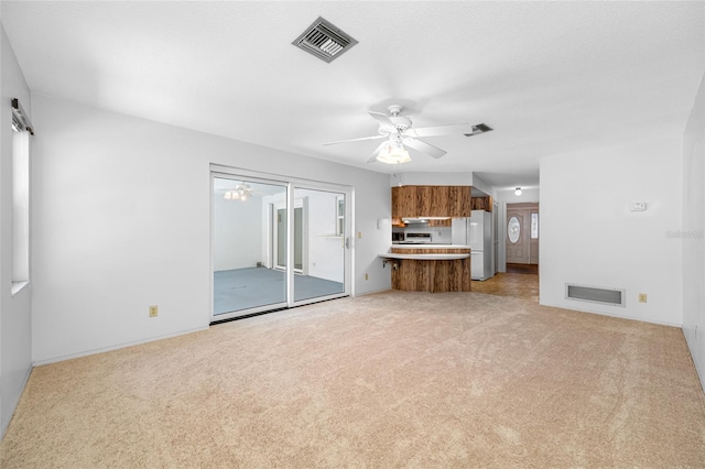 1211 Stony Brook Ln, Dunedin, FL 34698 - unfurnished living room featuring light carpet, a ceiling fan, and baseboards