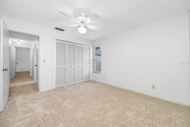 1211 Stony Brook Ln, Dunedin, FL 34698 - unfurnished bedroom with light carpet, a closet, and a ceiling fan