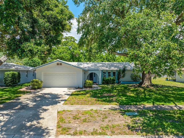 1211 Stony Brook Ln, Dunedin, FL 34698 - ranch-style home featuring an attached garage, stucco siding, a front yard, and driveway