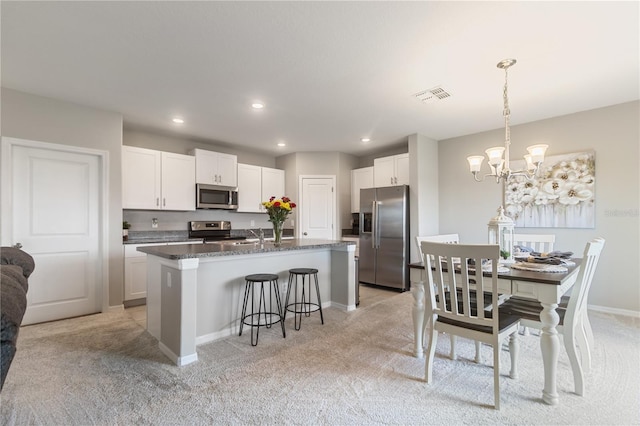 6180 Spring Crayfish Ave, New Port Richey, FL 34653 - kitchen with stainless steel appliances, light carpet, a kitchen breakfast bar, a kitchen island with sink, and recessed lighting