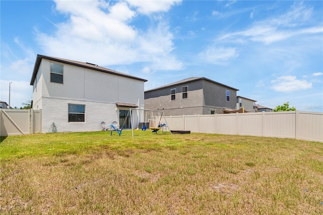 6180 Spring Crayfish Ave, New Port Richey, FL 34653 - back of house with stucco siding and a playground