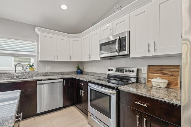6741 51st Way N, Pinellas Park, FL 33781 - kitchen with appliances with stainless steel finishes, a sink, white cabinets, dark brown cabinets, and recessed lighting