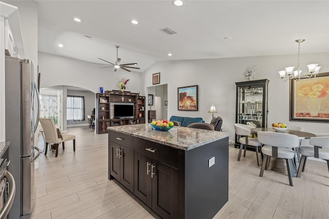 6741 51st Way N, Pinellas Park, FL 33781 - kitchen with freestanding refrigerator, arched walkways, open floor plan, lofted ceiling, and a kitchen island