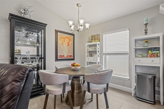6741 51st Way N, Pinellas Park, FL 33781 - dining area with a chandelier, light wood-type flooring, and baseboards
