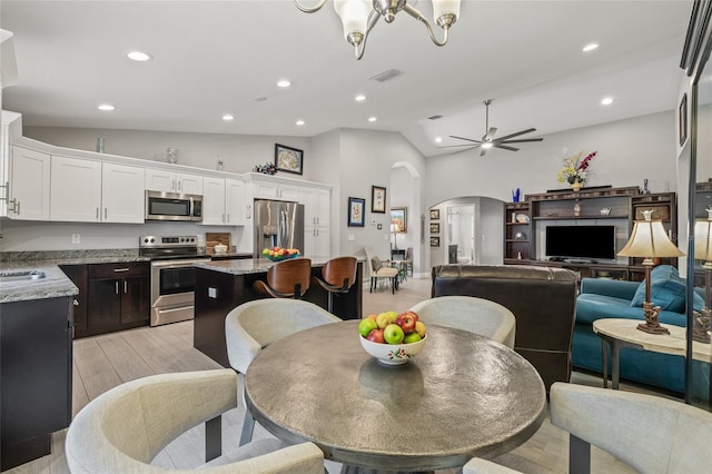 6741 51st Way N, Pinellas Park, FL 33781 - dining room with arched walkways, recessed lighting, light wood-style floors, ceiling fan, and high vaulted ceiling