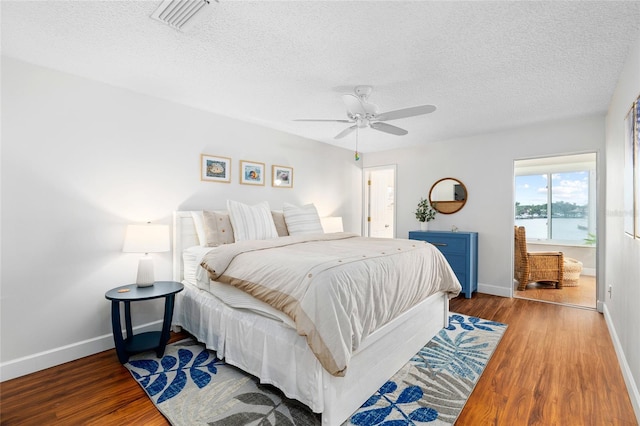 6075 Shore Blvd S Unit 215, Gulfport, FL 33707 - bedroom featuring wood finished floors, a textured ceiling, baseboards, and a ceiling fan