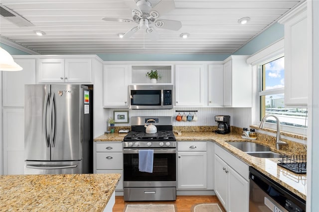 6075 Shore Blvd S Unit 215, Gulfport, FL 33707 - kitchen featuring stainless steel appliances, a sink, open shelves, and white cabinetry