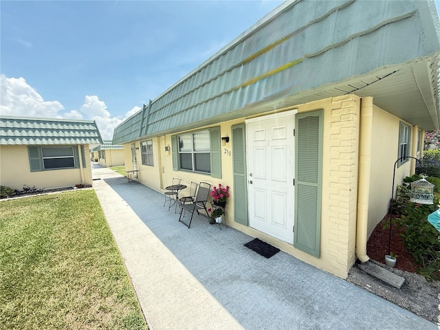 102 Cambridge Trl Unit 230, Sun City Center, FL 33573 - entrance to property featuring mansard roof, a yard, and stucco siding