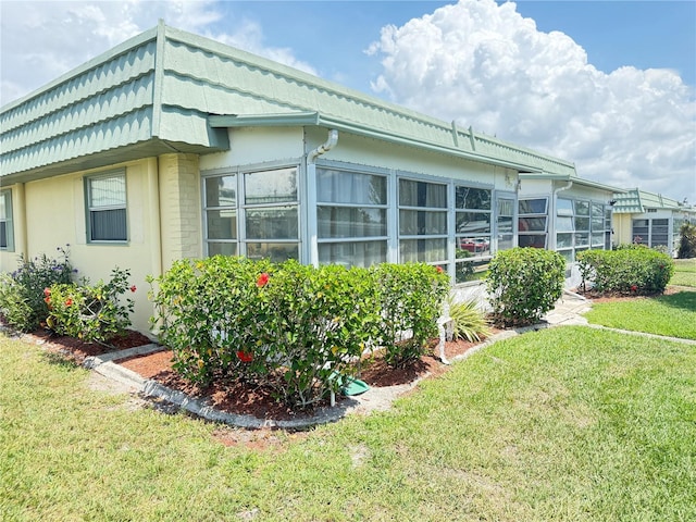 102 Cambridge Trl Unit 230, Sun City Center, FL 33573 - view of side of home featuring a lawn and stucco siding